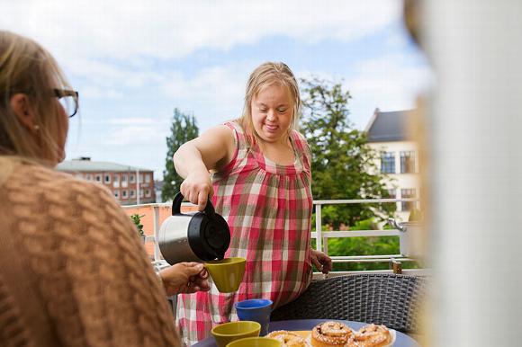 Lady with downs syndrome poring tea